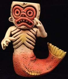 a figurine of a creature holding a fish