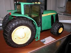 a green toy tractor sitting on top of a table