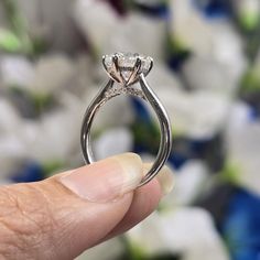 a close up of a person holding a diamond ring