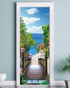 an open door with a scenic view of the ocean and stairs leading to a wooden bridge