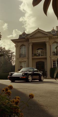 a black car parked in front of a large house