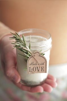 a person holding a small jar with some herbs in it and a tag that says made with love