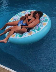 two people are laying on an inflatable float