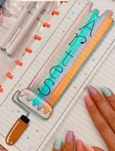 a woman's hand holding a pen and writing on a notebook with the words acrylic