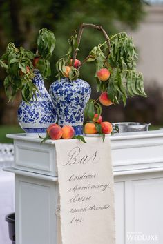 two vases with peaches on top of a table