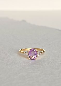 Our Fleur Amethyst ring features a single soft purple faceted Amethyst stone set in a sturdy four-prong setting surrounded with three white topaz on each side. It can be worn as an engagement ring and a statement ring stacked with our Colline and Hana ring for a unique look. Always handmade with genuine and natural stones on solid sterling silver and thick gold vermeil that will stand the test of time. D E T A I L S * Materials - 18k gold vermeil on solid 925 sterling silver, genuine faceted Ame Timeless Purple Rings As Gifts, Timeless Purple Rings Perfect For Gifts, Timeless Purple Rings For Gifts, Timeless Amethyst Ring As A Gift, Minimalist Gold Amethyst Ring, Modern Yellow Gold Amethyst Ring For Wedding, Modern Yellow Gold Amethyst Wedding Ring, Modern Yellow Gold Amethyst Ring With Accent Stones, Elegant 14k Gold Amethyst Open Ring