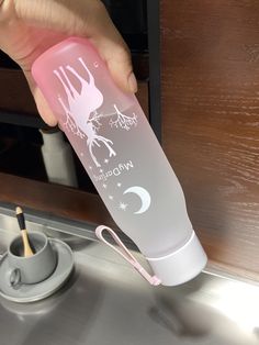 a person holding a pink and white water bottle