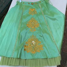 Sugar Lips, Gorgeous Iridescent Apple Green Skirt With Golden Embroidery & Sequins L Up Front, Gems Along Waist & Along Front Panel, A-Line Cut, Hidden Side Zipper, Peekaboo “Crinoline” Bottom Accent, Never Worn, Catches Light To Shimmer, Fully Lined, Stunning And Unique, Perfect For Cocktails, Art Opening, Summer Outdoor Event, Dinner Date, Semi Formal, Unique, Boho, Artsy, Shimmer, Sophisticated, Eye Catching, Fun! Waist 14.5” Measured Flat. Festive Embellished Long Skirt, Green Embellished Party Skirt, Festive Fitted Green Skirt, Elegant Green Festive Skirt, Traditional Embellished Festive Skirt, Traditional Green Embroidered Skirt, Traditional Embellished Long Skirt, Traditional Embellished Skirt For Festive Occasions, Traditional Long Embellished Skirt