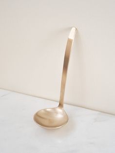 a gold spoon sitting on top of a white counter