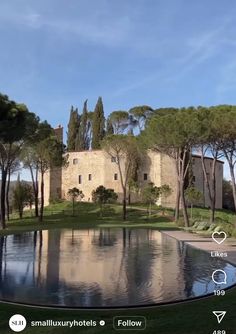 an image of a house in the distance with trees around it and a pond on the side