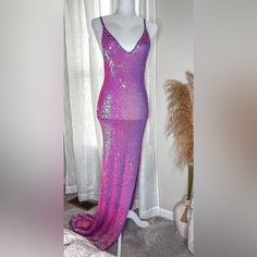 a purple sequin dress on display in front of a window