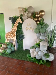 a giraffe themed birthday party with balloons and greenery on the floor,