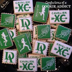 cookies decorated with green and white icing are on a black platter that says cavaller xc