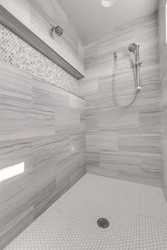 a white tiled bathroom with a shower head