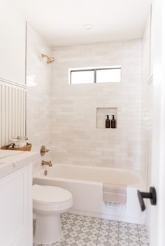 a bathroom with a toilet, sink and bathtub