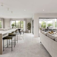 a living room filled with furniture next to a kitchen and an open concept dining area