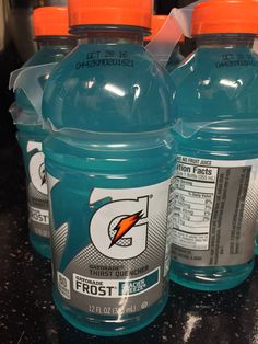 three bottles of gatorade sitting on top of a counter