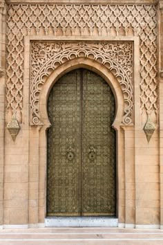 the entrance to an old building with large wooden doors and intricate carvings on it's sides