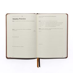 an open notebook with the words weekly review written in black and brown ink on it