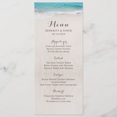 the beach wedding menu is displayed on a marble table