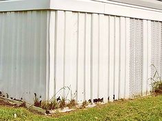 a white building sitting on top of a lush green field