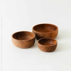 three wooden bowls sitting next to each other