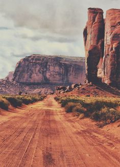 a dirt road in the desert with large rocks