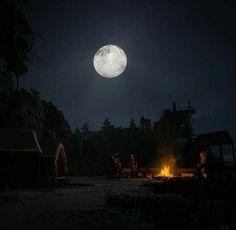 people sitting around a campfire at night with the moon in the background