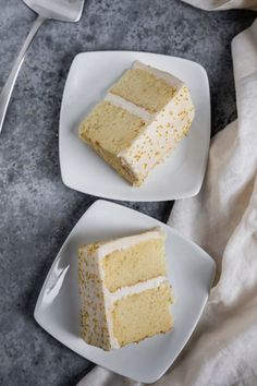 two slices of white cake on plates with forks and spoons next to each other