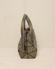 Boston bag by Bao Bao Issey Miyake in khaki green. Classic hand or shoulder bag with twin adjustable straps. Handy size with sturdy base and studded feet. Compact rectanguar shape offers a deceivingly spacious capacity, while the signature triangular motif has a reflective leather-like finish. H 16.5cm x W 33cm.Polyvinyl Chloride, Polyster, Nylon.Made in Japan. On-the-go Baguette Bag With Removable Pouch, Modern Box Bag With Silver-tone Hardware, Baobao Bag, Modern Togo Leather Bag With Silver-tone Hardware, Issey Miyake Bao Bao, Bao Bao Issey Miyake, Bao Bao, Polyvinyl Chloride, Boston Bag