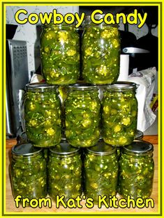 a stack of jars filled with pickles sitting on top of a wooden table