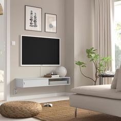 a living room with a couch, chair and television on the wall in front of it