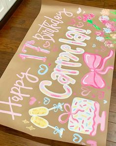 a large sheet of brown paper with pink and blue lettering on it that says happy birthday