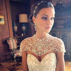 a woman wearing a wedding dress with an open back and beading on the shoulders