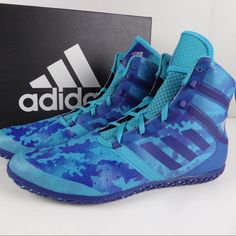 the adidas basketball shoe is blue and has camouflage print on it, with purple accents