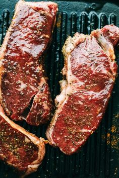 two steaks on a grill with seasoning