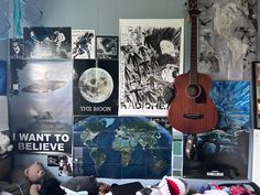 a guitar is sitting in front of many posters