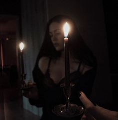 a woman holding a lit candle in her hand