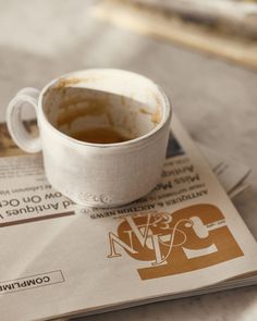 a cup of coffee sitting on top of a newspaper