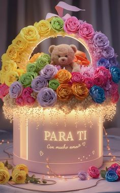 a teddy bear is sitting in a flower basket with roses on the table and lights around it