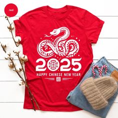 Customers who bought this t-shirt also bought our Custom Text T-Shirt. (https://www.etsy.com/listing/1765745872/custom-text-t-shirt-custom-text-4xl-5xl?) Christmas Family T-shirts Welcome! In our T-shirt store, you'll find a wide range of high-quality, comfortable, and stylish T-shirts for men, women, and kids. We offer various options, from classic solid colors to vibrant graphics and designs inspired by pop culture. Our T-shirts are crafted using premium materials to ensure they are gentle on Lunar New Year Party, Snake Shirt, Chinese Lunar New Year, Family T Shirts, Text T Shirt, Year Of The Snake, New Years Shirts, Happy Thanksgiving Day, New Year Party