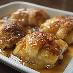 some kind of pastry on a white plate with caramel sauce and syrup in it