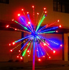 a pole with lights on it in front of a building and garage doors at night