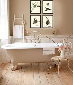 a white bath tub sitting next to a wooden floor