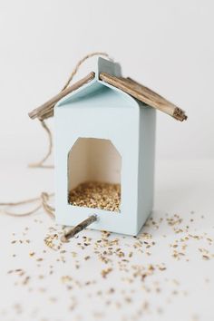 a blue birdhouse with a piece of wood sticking out of it