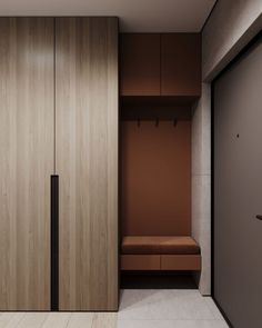 an empty room with wooden closets and brown furniture on the wall, next to a bench