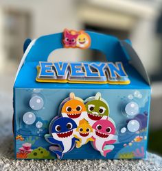 an open blue box with two little fish on it's side and the word evelyn written in large letters