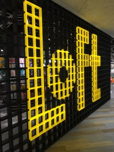 a black and yellow wall that has some type of design on it, along with bookshelves in the background