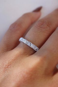 a woman's hand with a wedding band on it and the ring is in white gold