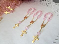 "20 Rosarios pequeñitos o decenario en color rosa., hechos a Mano con la Imagen de la virgen de Guadalupe , bañados en Oro y hechos de acrilico con figurita de rosa. Mide cerca de 10cm de largo y Las cuentitas importados son de 6 mm. 20 PINK COLOR , ACRYLIC BEADS IN SHAPE OF ROSEBUDS ON THIS MINI ROSARIES . ALL HAND MADE AND GOLD PLATED THEY MEASURE ABOUT 4\" INCHES EACH. COMVO US WITH Any QUESTIONS. Thanks!" Personalized Pink Rosary Bracelet For Baptism, Pink Rosary For First Communion, Pink Rosary With Round Beads For First Communion, Handmade Pink Rosary For Baptism, Handmade Pink Rosary For First Communion, Handmade Pink Rosary With Cross, Handmade Pink Rosary With Cross Shape, Handmade Pink Jewelry For Baptism, Handmade Pink Cross Rosary